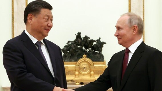 Wladimir Putin (r), Präsident von Russland, und Xi Jinping, Präsident von China, geben sich vor ihren Gesprächen im Kreml die Hand. © Sergei Karpukhin/Pool Sputnik Kremlin via AP/dpa 