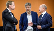 Daniel Günther (CDU), Ministerpräsident von Schleswig-Holstein, Robert Habeck (Bündnis 90/Die Grünen), Bundesminister für Wirtschaft und Klimaschutz, und Bundeskanzler Olaf Scholz (SPD) stehen in einem Sitzungssaal nebeneinander. © dpa bildfunk Foto: Bernd von Jutrczenka