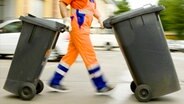 Ein Müllmann schiebt zwei Mülltonnen. © dpa - Bildfunk Foto: Frank Rumpenhorst