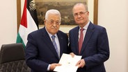Mahmoud Abbas (l) übergibt Mohammad Mustafa in Ramallah ein Papier, das ihn mit der Regierungsbildung der 19. Regierung im Westjordanland beauftragt. © picture alliance / Xinhua News Agency | Palestinian President Office 