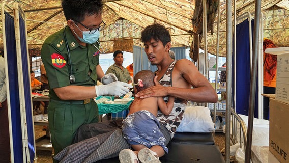 Ein freiwilliger Sanitäter des Militärs behandelt einen Patienten in einem provisorischen Zelt nach dem Erdbeben in Myanmar. © dpa bildfunk/AP 