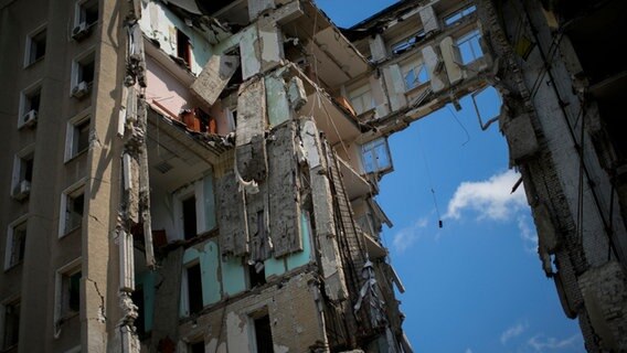 Trümmerteile hängen am Sitz der Regionalregierung von Mykolaiv in der Ukraine. © Francisco Seco/AP/dpa 