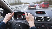 Ein Autofahrer sitzt am Steuer und blickt auf die Fahrzeuge auf der Autobahn vor ihm. © Fotolia Foto: Anya Berkut