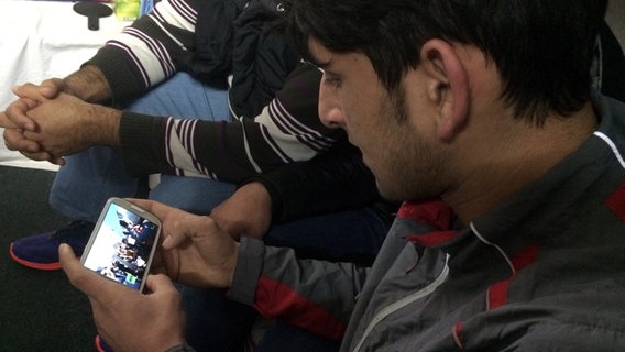 Nazim guckt auf sein Smartphone. © NDR Foto: Bettina Less