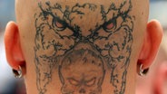 Der Hinterkopf eines Anhängers der rechtsextremen Szene mit Glatze und Totenkopf-Tätowierung. © dpa - Bildfunk Foto: Bernd von Jutrczenka