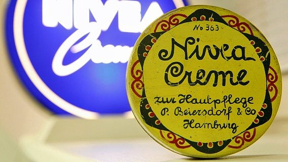 Eine historische Nivea-Dose des Unternehmens Beiersdorf in Hamburg vor einem moderneren Design. Eine historische Nivea-Dose des Unternehmens Beiersdorf in Hamburg vor einem moderneren Design. © dpa Foto: Jens Ressing
