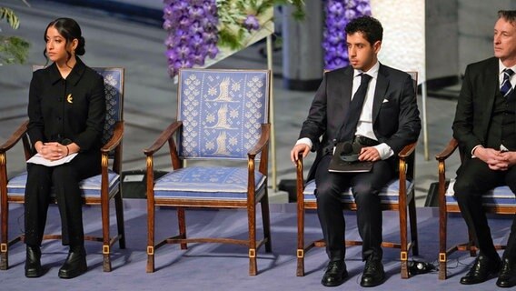 Kiana (l.) und Ali Rahmani, Tochter und Sohn von der im Iran inhaftierten Narges Mohammadi, während der Verleihung des Friedensnobelpreises 2023 im Rathaus von Oslo. Narges Mohammadi aus dem Iran erhält den Friedensnobelpreis für ihren Kampf gegen die Unterdrückung der Frauen im Iran und für den Kampf für Menschenrechte und Freiheit für alle. © Fredrik Varfjell/NTB/dpa 