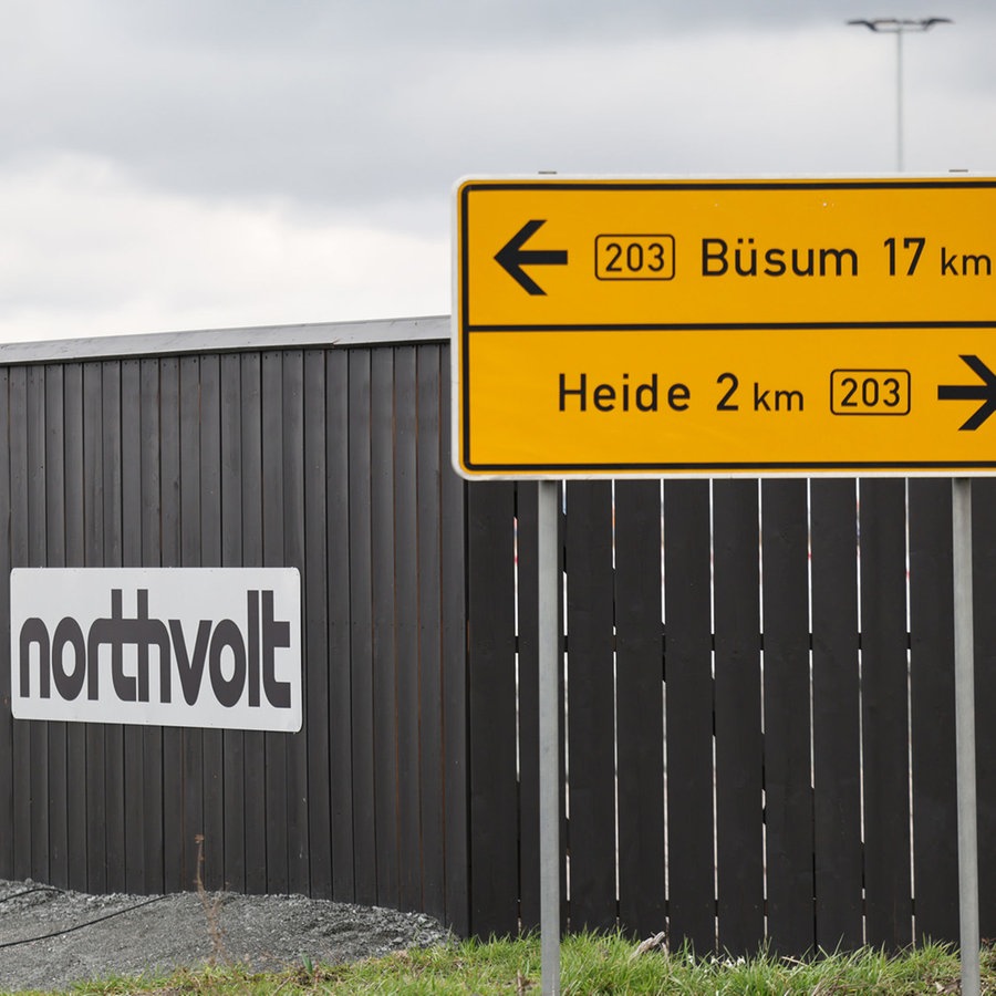 Der Schrift·zug Northvolt hängt an einem Zaun. Dieser Zaun ist an dem Eingang zu der Bau·stelle von der Fabrik. © Christian Charisius/dpa +++ dpa-Bildfunk +++ Foto: Christian Charisius/dpa