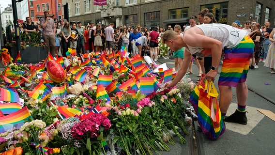 Teilnehmer einer spontanen Pride-Parade legen in Oslo in Norwegen nach tödlichen Schüssen in einer Schwulen-Bar am Tatort Blumen nieder. © dpa bildfunk/AP Foto: Sergei Grits