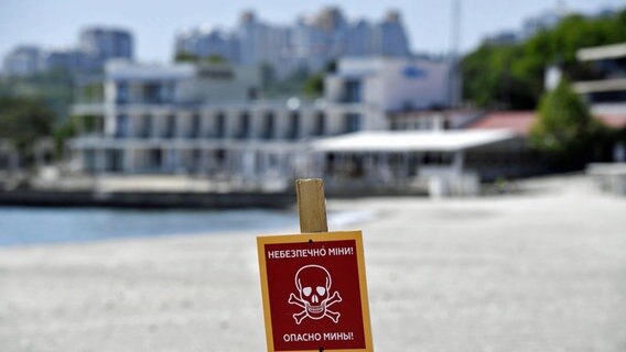 Ein Schild warnt vor Landminen an einem Strand in Odessa in der südlichen Ukraine. © -/kyodo/dpa 
