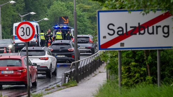 Bundespolizisten stehen am Grenzübergang zwischen dem Ort Freilassing (Deutschland) und der Stadt Salzburg (Österreich) auf der Saalachbrücke und kontrollieren die Einreise. © Peter Kneffel/dpa 