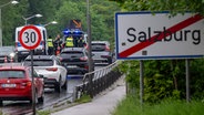 Bundespolizisten stehen am Grenzübergang zwischen dem Ort Freilassing (Deutschland) und der Stadt Salzburg (Österreich) auf der Saalachbrücke und kontrollieren die Einreise. © Peter Kneffel/dpa 
