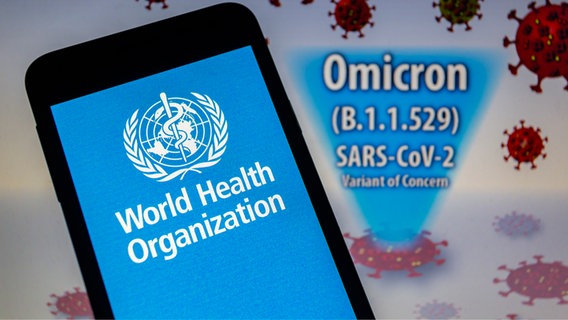 Logo der Weltgesundheitsorganisation (WHO) auf einem Smartphone vor einer visuellen Darstellung der neu entdeckten Virusvariante Omikron © picture alliance Foto: Andre M. Chang