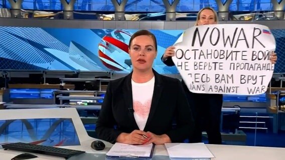 Der Screenshot aus der abendlichen Hauptnachrichtensendung des russischen Staatsfernsehen zeigt die Protestaktion von Marina Ovsyannikova mit einem Plakat gegen den Krieg in der Ukraine. © Screenshot Social Media/dpa 