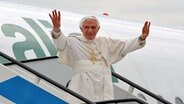 Papst Benedikt steigt aus einem Flugzeug und hebt grüßend beide Arme. © dpa bildfunk Foto: Claudio Onorati