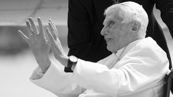 Der emeritierte Papst Benedikt XVI. sitzt 2020 am Flughafen München auf dem Vorfeld in seinem Rollstuhl vor seiner Abreise nach seinem viertägigen Besuch in Regensburg zurück in den Vatikan. © picture alliance Foto: Sven Hoppe