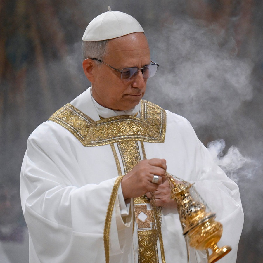 Der Papst Leo XIV. feiert seine erste Messe in seinem neuen Amt in der Sixtinischen Kapelle und schwingt ein goldenes Weihrauchfass aus dem racuh aufsteigt. © Uncredited/Vatican media/AP/dpa 