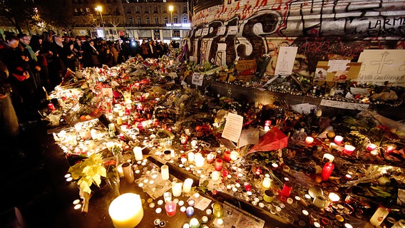 Menschen entzünden am 15.11.2015 auf dem Platz der Republik in Paris (Frankreich) Kerzen und legen Blumen nieder. © dpa Foto: Malte Christians