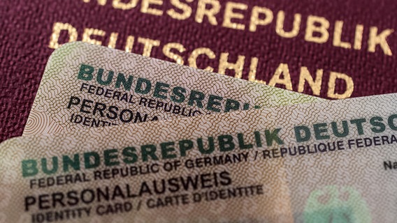 Zwei deutsche Personalausweise und ein Reisepass liegen übereinander. © dpa picture alliance/Zoonar | stockfotos-mg 