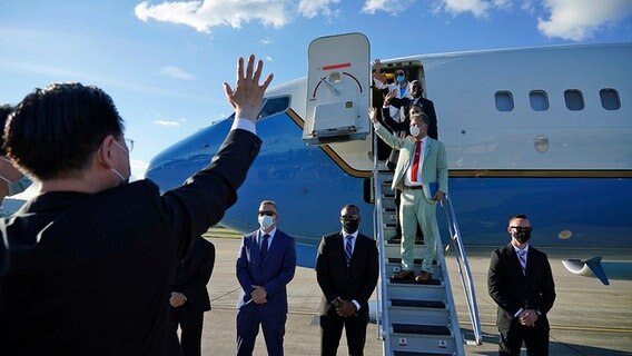 Nancy Pelosi (hinten), Sprecherin des US-Repräsentantenhauses, und andere Mitglieder der US-Delegation, winken von einer Treppe an einem Flugzeug. © Uncredited/Taiwan Ministry of Foreign Affairs/AP/dpa 