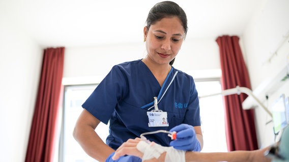 Eine Pflegekraft legt einer Patientin eine Infusion. © picture alliance/dpa Foto: Oliver Dietze