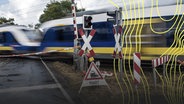 Der Bahnübergang am Schanzer Weg ist während der Zugdurchfahrt gesperrt © picture alliance Foto: Sina Schuldt