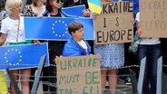 Demonstranten, die die Ukraine unterstützen, stehen mit Schildern und EU-Fahnen während einer Demonstration vor dem EU-Gipfel in Brüssel © picture alliance/dpa/AP | Olivier Matthys Foto: Olivier Matthys