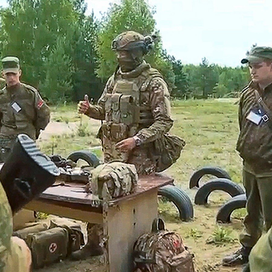 Ein Ausbilder der Söldnerarmee Wagner spricht zu belarussischen Soldaten während eines Trainings in der Nähe des Dorfes Tsel, etwa 90 Kilometer südöstlich von Minsk. © picture alliance Foto: Belarussisches Verteidigungsministerium