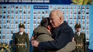 Joe Biden und Wolodymyr Selenskyj umarmen sich zum Abschied an der
Gedenkmauer für die gefallenen Verteidiger der Ukraine. © picture alliance 