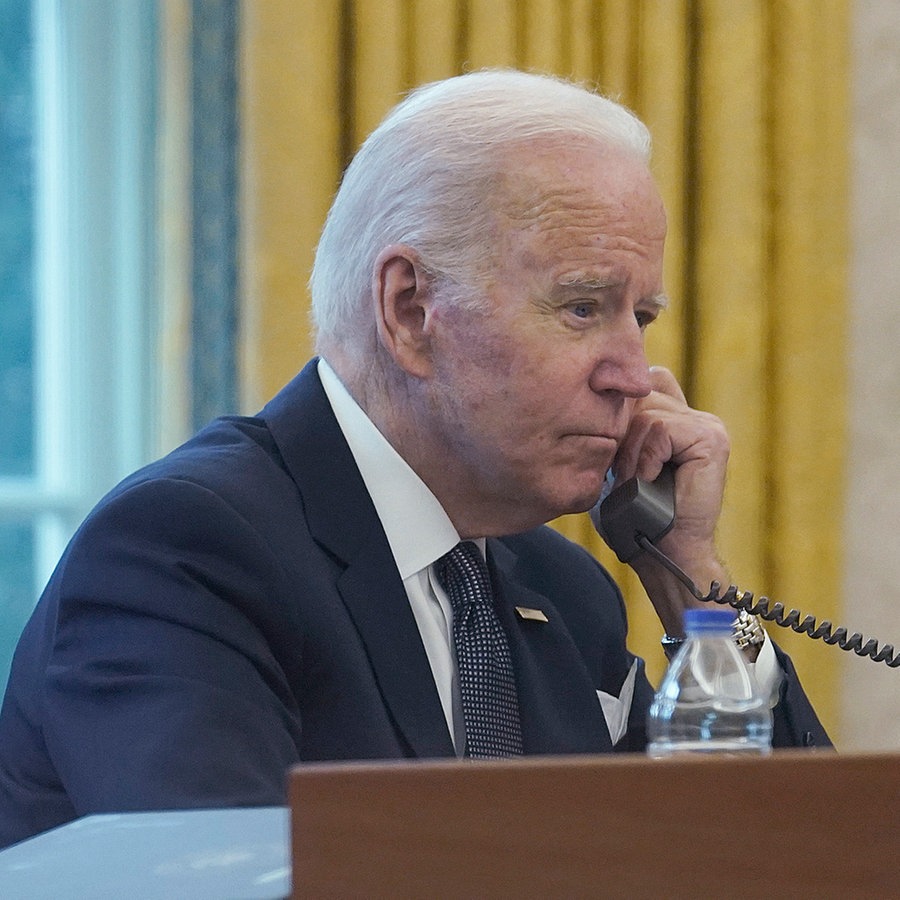 Auf diesem Bild, das durch ein Fenster aufgenommen wurde, telefoniert der Präsident der USA, Joe Biden, im Oval Office des Weißen Hauses. © AP/dpa Foto: Susan Walsh