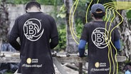 Zwei junge Männer mit Bitcoin-Shirts von hinten in El Salvador. © IMAGO Foto: Miguel Lemus