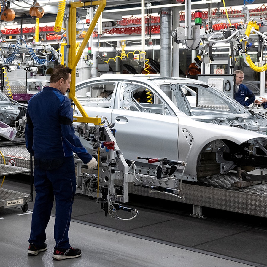 Mitarbeiter von BMW arbeiten im Stammwerk in der Produktion an der Karosserie von verschiedenen Modellen des Autoherstellers. © picture alliance/dpa Foto: Sven Hoppe