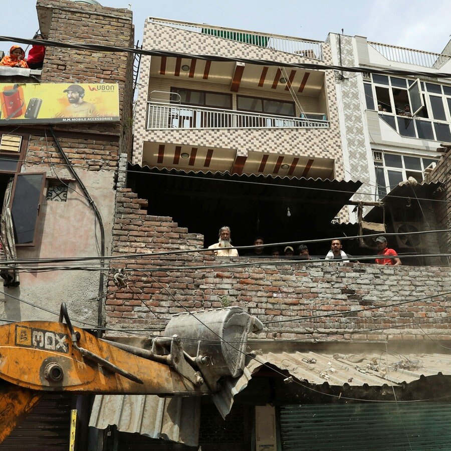 Ein Bulldozer soll ein illegales Haus in Neu-Delhi abreissen. © Reuters 