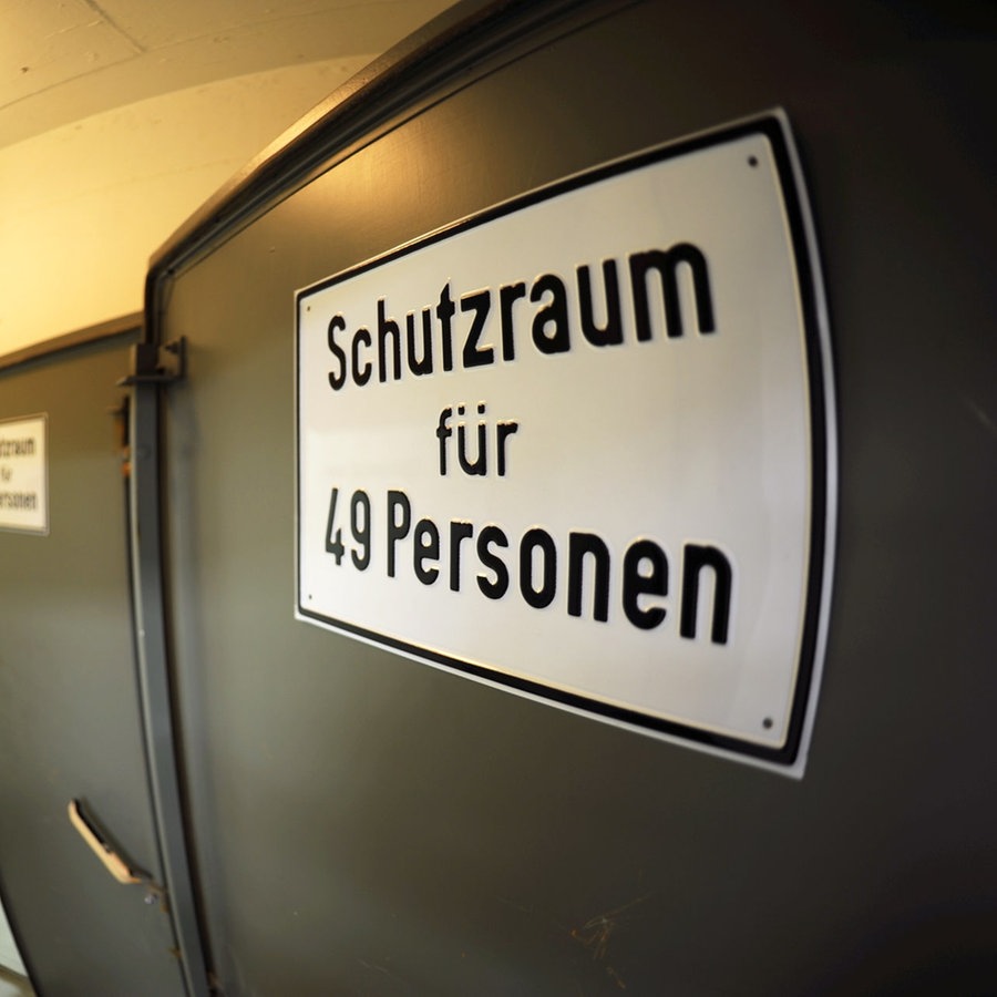 Ein Schild weist auf einen Schutzraum in einem stillgelegten Bunker der Staatsregierung in Geretsried in Oberbayern  hin. © picture alliance Foto: Arne Meyer