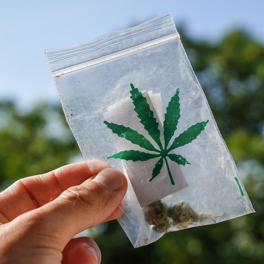 Hand hält einen Beutel mit selbst angebautem Marihuana bzw. Cannabis. © picture alliance Foto: MICHAEL BIHLMAYER