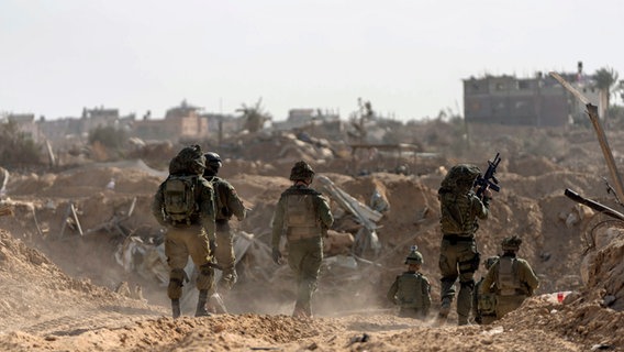 Israelische Soldaten gehen während einer Bodenoperation in Stellung in Chan Junis (Gazastreifen). © AP Foto: Ohad Zwigenberg