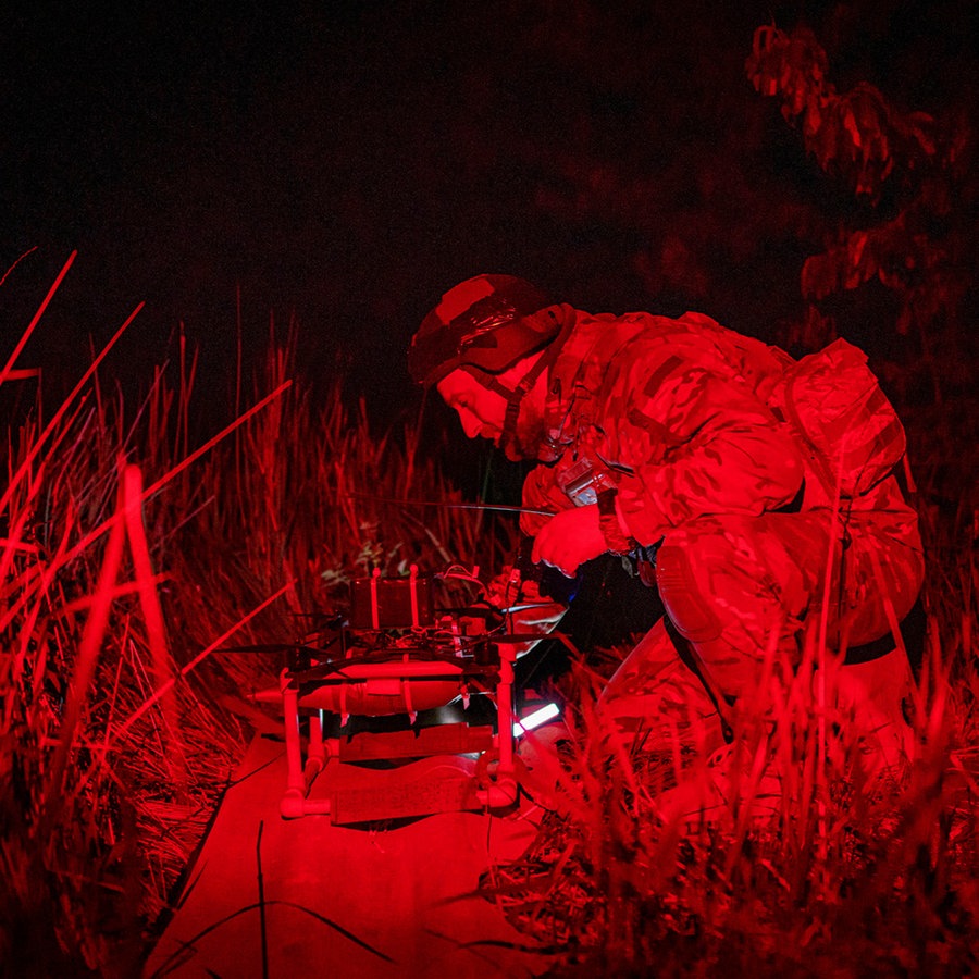 Ein ukrainischer Soldat schaltet eine FPV-Drohne in der Startposition ein, bevor er sie über russische Stellungen in der Region Charkiw fliegen lässt. © AP/dpa Foto: Evgeniy Maloletka