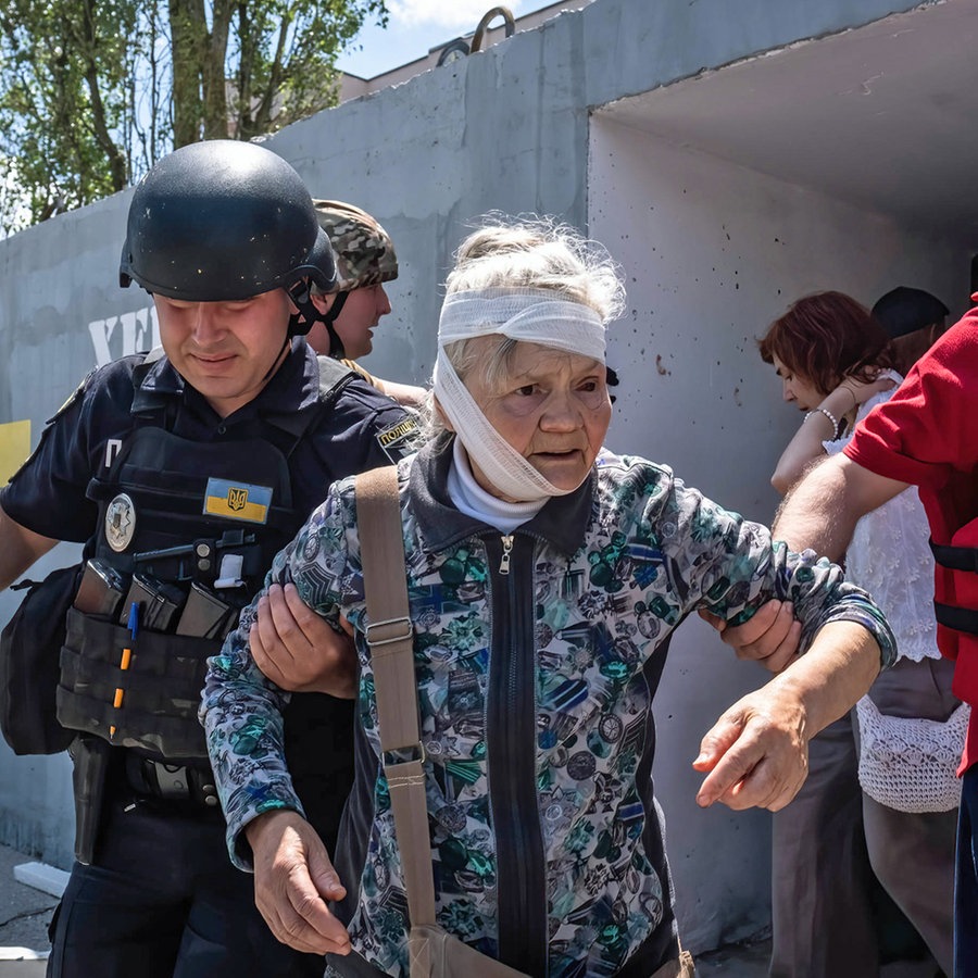 Rettungskräfte bringen eine verletzte alte Dame in der ukrainischen Stadt Cherson (Ukraine9 zu einem Krankenwagen. © SOPA Images via ZUMA Press Wire/dpa Foto: Alex Chan