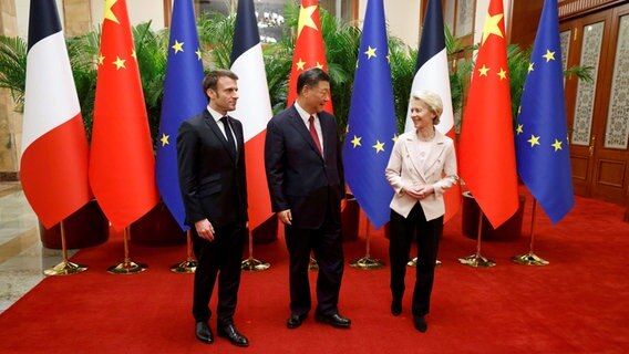 Der Präsident von Frankreich Emmanuel Macron (links), der Präsident von China, Xi Jinping, und die Präsidentin der Europäischen Kommission, Ursula von der Leyen, stehen für ein offizielles Foto in Peking zusammen. © Pool AFP/AP/dpa Foto: Ludovic Marin