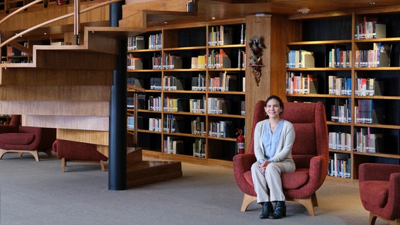 Adriana Rodriguez sitzt in einer Bibliothek. © NDR / Zeitenspiegel / Jelca Kollatsch Foto: Jelca Kollatsch