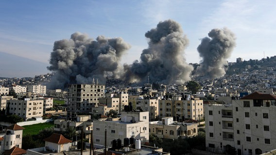 Nach einer Explosion der israelischen Armee, die nach eigenen Angaben von militanten Palästinensern genutzte Gebäude im Flüchtlingslager Dschenin im Westjordanland zerstörte, steigt Rauch auf. © AP/dpa Foto: Majdi Mohammed