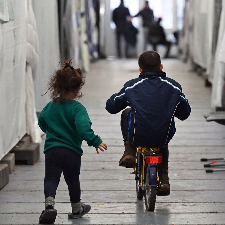 Geflüchtete Kinder sind in einer improvisierten Flüchtlingsunterkunft unterwegs. © dpa Foto: Arne Dedert