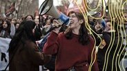 Eine junge Frau mit Megafon steht vor einer Protestbewegung in Frankreich. © Imago Images Foto: Alexis Sciard