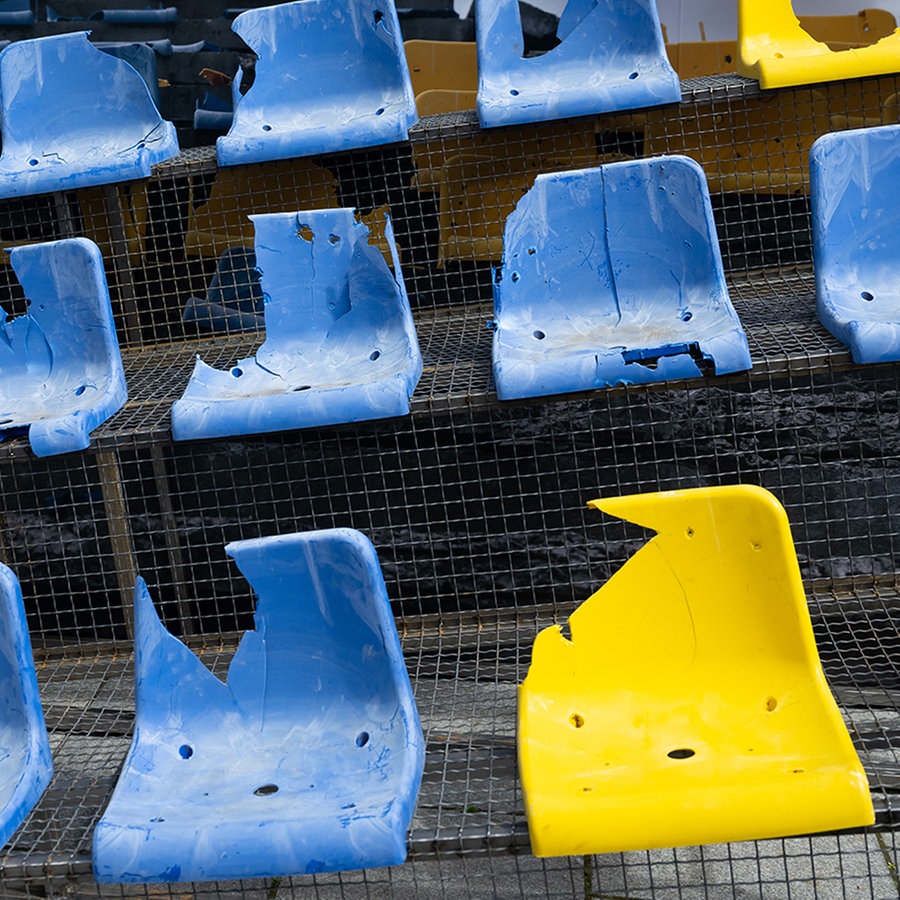 Fußballsitze aus dem von russischen Angriffen zerstörten Stadion in Charkiw sind auf dem Wittelsbacherplatz bei einer Kundgebung aufgebaut. Das Stadion in Charkiw war Austragungsort der Euro 2012. © picture alliance Foto: Sven Hoppe