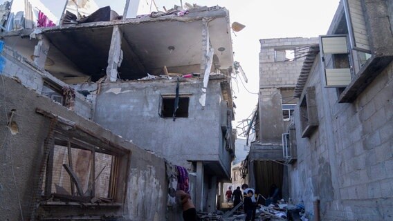 Palästinenser inspizieren ein beschädigtes Gebäude nach israelischen Luftangriffen © dpa-Bildfunk Foto: Fatima Shbair