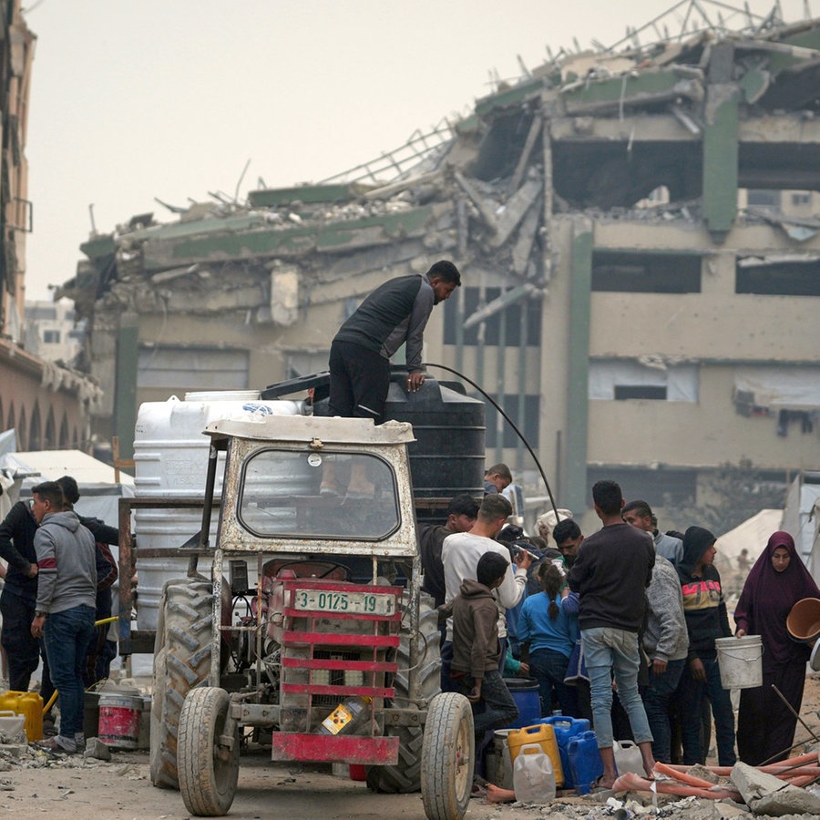 In der Islamischen Universität, die jetzt als Unterkunft für vertriebene Palästinenser inmitten des anhaltenden Konflikts in Gaza-Stadt dient, wird Wasser verteilt. © AP/dpa Foto: Jehad Alshrafi