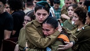 Israelische Soldatinnen weinen auf einer Trauerfeier für Lavi Lipshitz, der im Gaza-Streifen bei der Bodenoffensive ums Leben gekommen ist. © picture alliance Foto: Ilia Yefimovich