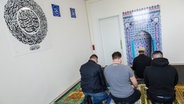 Ein muslimischer Seelsorger betet gemeinsam mit Häftlingen im Gebetsraum in einer Justizvollzugsanstalt. © dpa Foto: Silas Stein