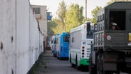 Busse mit ukrainischen Soldaten stehen in der Nähe eines Gefängnisses in der Region Donezk. © picture alliance Foto: Alexei Alexandrov