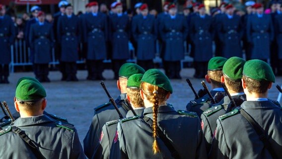 Feierliches Gelöbnis der Bundeswehr auf einem Markplatz mit Soldaten und Soldatinnen der Ehrenformation. Im Hintergrund sind Rekruten und Rekrutinnen der Bundeswehr zu sehen. © dpa Foto: Klaus-Dietmar Gabbert